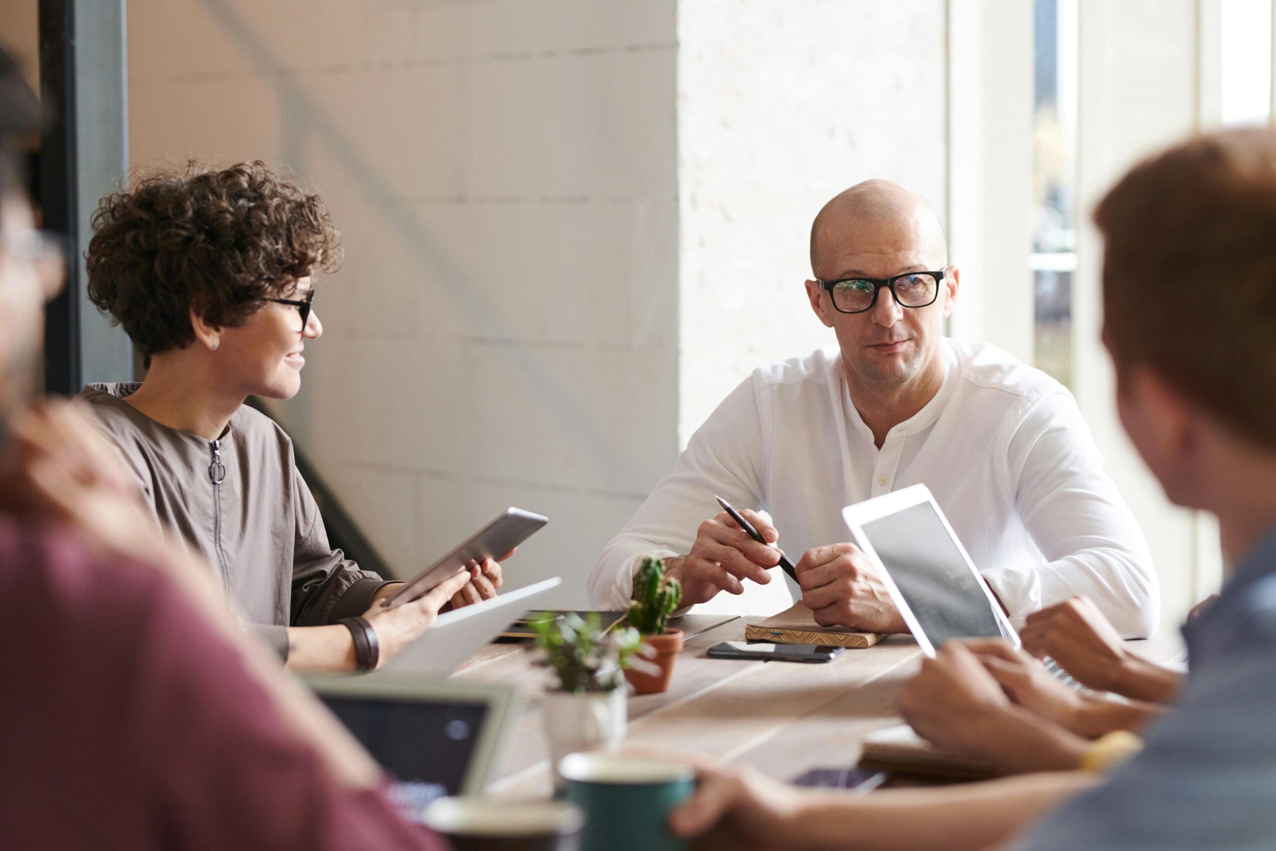 Group of professionals engaged in a brainstorming session around a table in a contemporary office space.